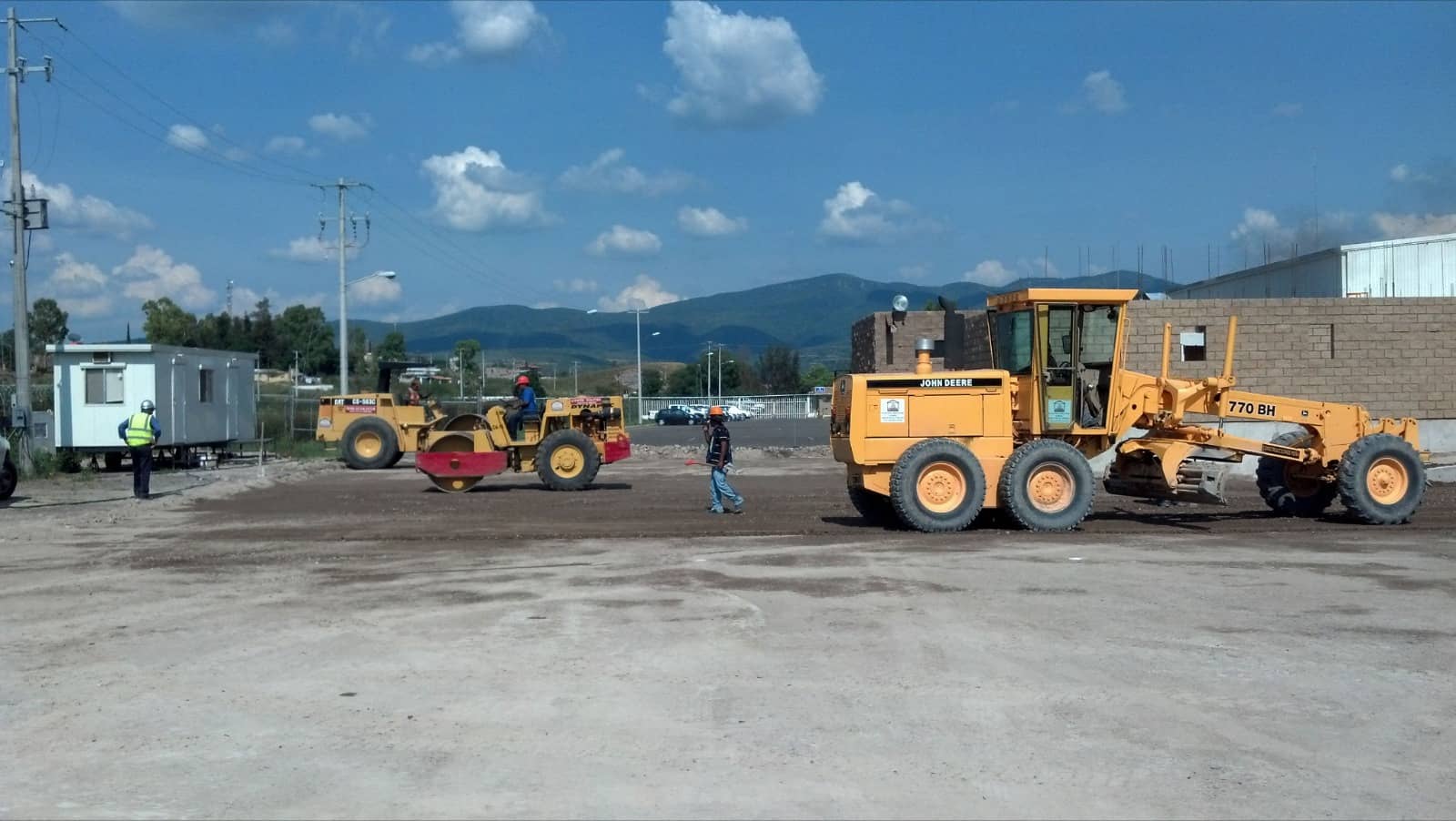 Patio de maquinaria de Construcciones Peña con motoconformadora y vibrocompactador