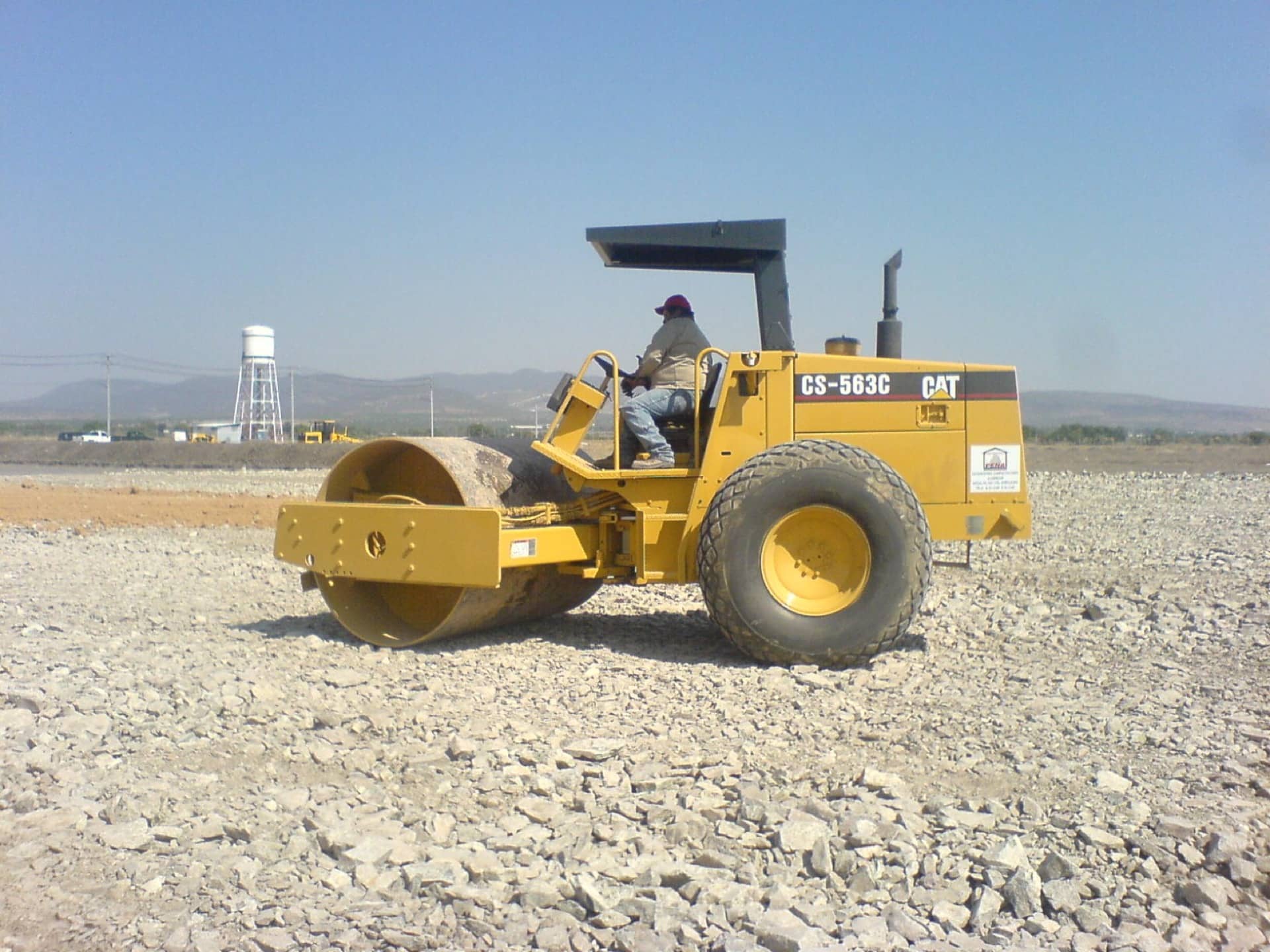 Vibrocompactador Caterpillar CS-563C de 12 toneladas compactando base hidráulica